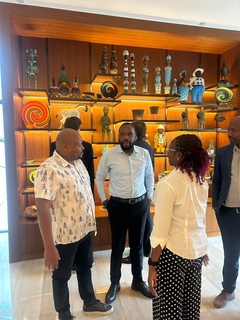 Members of the Twende Green Planet team in conversation with a colleague in a hotel lobby