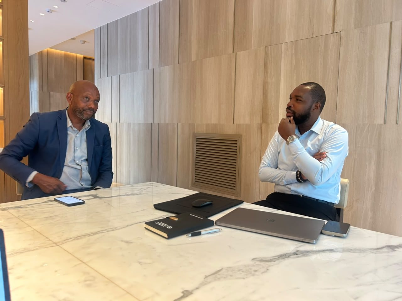 Two members of the meeting in conversation across a marble table